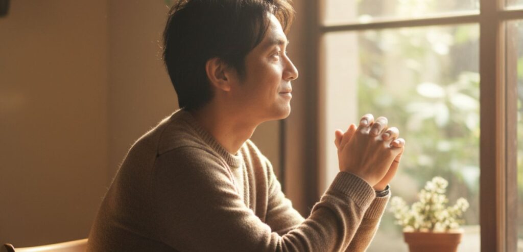 静かな時間の中で考えを深める男性の横顔。読書を通じて他者の人生を想像し共感力を養うイメージ。